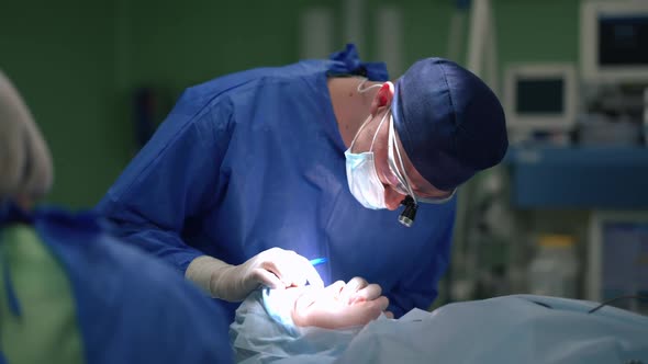 Medium Shot Professional Plastic Surgeon Wiping Blood From Face of Patient During Operation