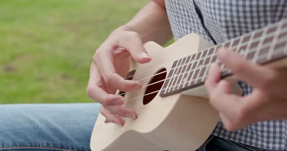 Woman play music on ukulele