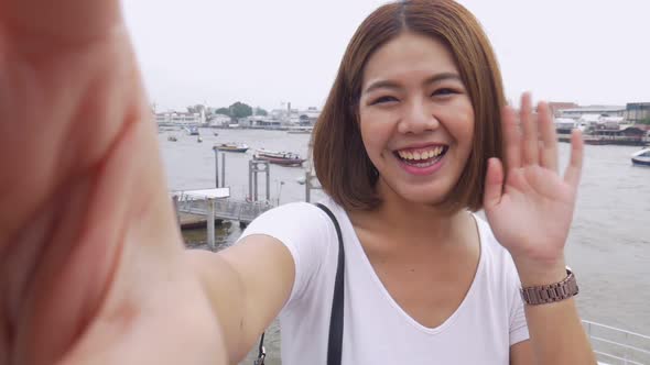 Smile beautiful Asian woman taking selfies on a smartphone.