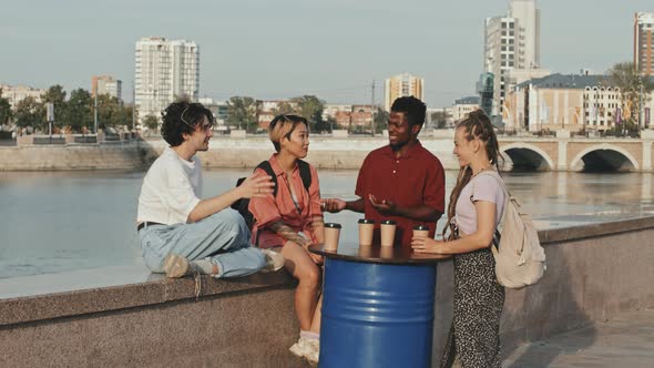 Diverse Friends Chatting on Embankment in Summer