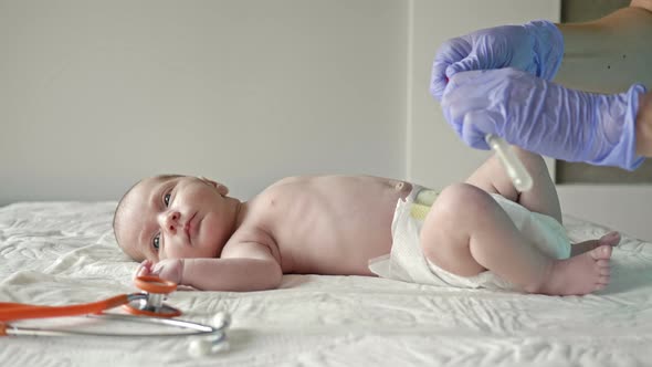 Nurse Takes a Swab From the Infant's Nose