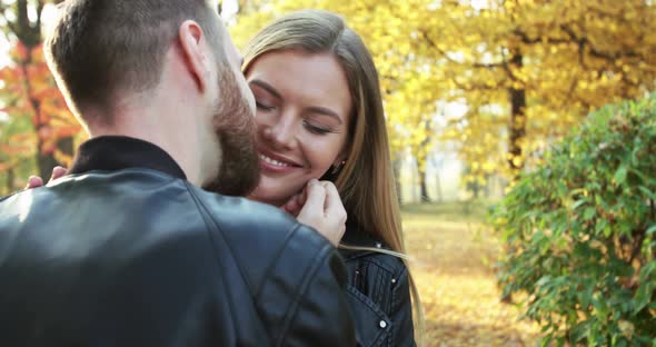 Macho Caresses and Kisses His Girlfriend's While They Stand Together in Park