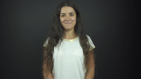 Girl with Long Loose Curly Hair Smiles Under Electric Light