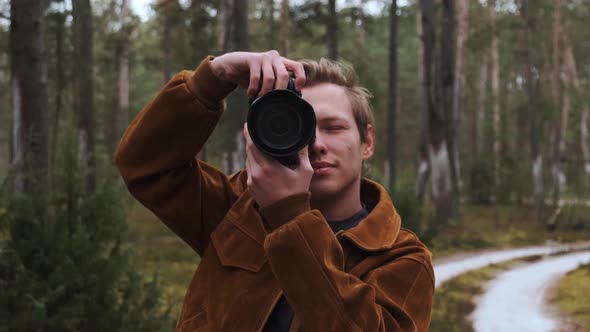 A Young Blond Male Photographer Takes Pictures of Nature