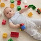 Little Smiling Baby Boy on Carpet in Playroom Covered with Colroful Toys Bricks and Blocks - VideoHive Item for Sale