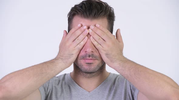 Young Handsome Hispanic Man Covering Eyes As Three Wise Monkeys Concept