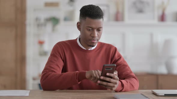 Successful African Man Celebrating on Smartphone