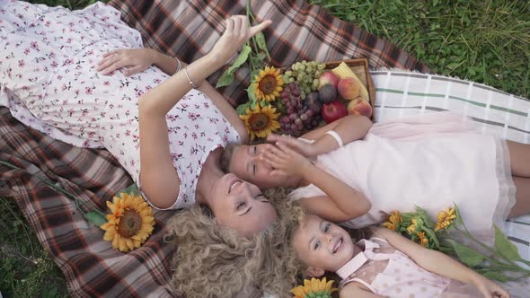 Relaxed Family Lying on Blanket Pointing Up Talking in Slow Motion Smiling