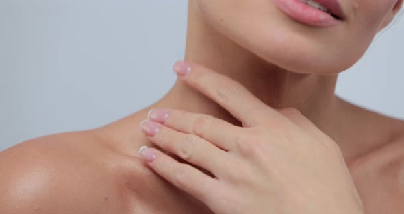 Closeup Portrait of Young Woman with Smooth Healthy Skin Gently Touches Her Shoulders and Face with