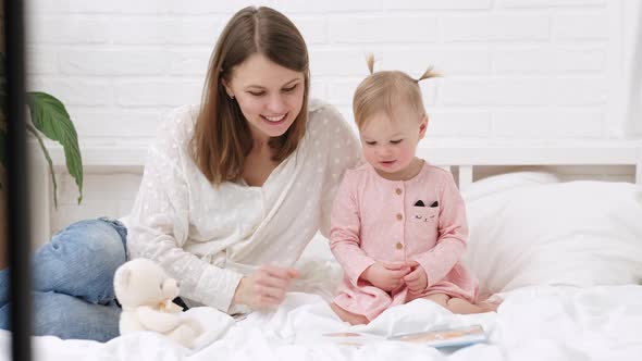 Mother and Baby Sonreading a Book in Bed Before Going to Sleep