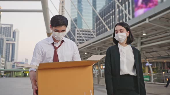 Asian business man with face mask walking outdoor feeling sad after losing the job from Covid 29.