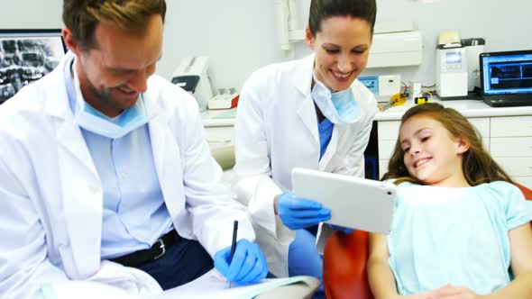 Dentist showing digital tablet to young patient