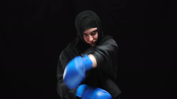 Concentrated Confident Muslim Woman Boxing Camera with Angry Facial Expression