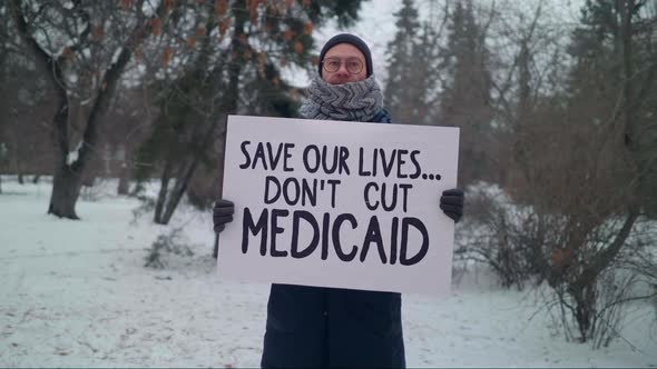 Man is Protesting against the law with a Sign Save Our Lives Don`t Cut Medicaid