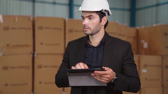 Factory Manager Using Tablet Computer in Warehouse or Factory