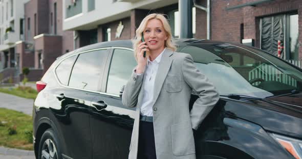 Business Confident Woman Talking on Phone Near Car Outdoors. Technology and People Concept