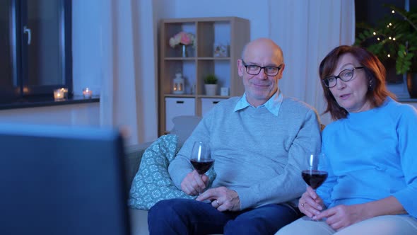 Happy Senior Couple Drink Red Wine and Watch Tv