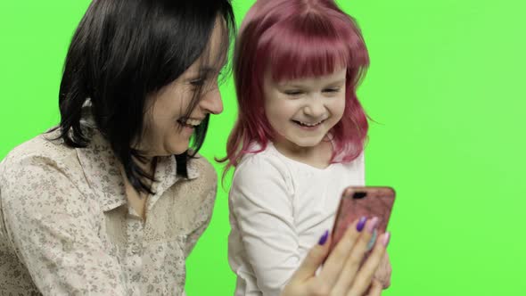 Mother, Daughter Holding, Using Smart Phone Talking on Video Call. Social Media