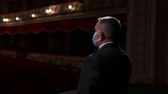 Theater actor speaks on a stage in medical mask. 