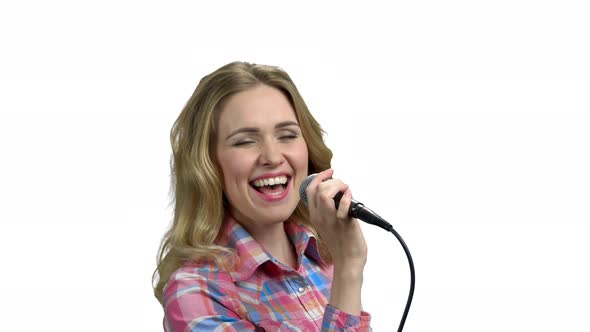 Charming Woman Singing in Microphone on White Background