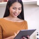 Young woman relaxing standing in kitchen and using digital tablet. - VideoHive Item for Sale