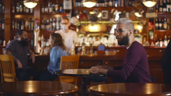 Happy Multiethnic Couple Meeting and Hugging in Modern Bar