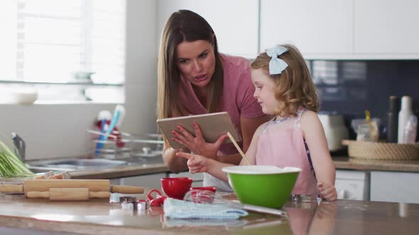 Caucasian mother and daughter having fun cooking together