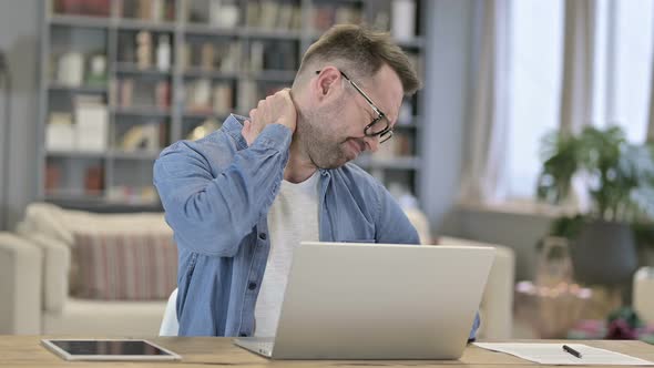 Hardworking Young Man Having Neck Pain in Loft Office 