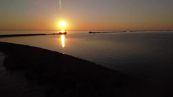 Beautiful aerial vibrant high contrast sunset over calm Baltic sea, rock pier at Port of Liepaja (La