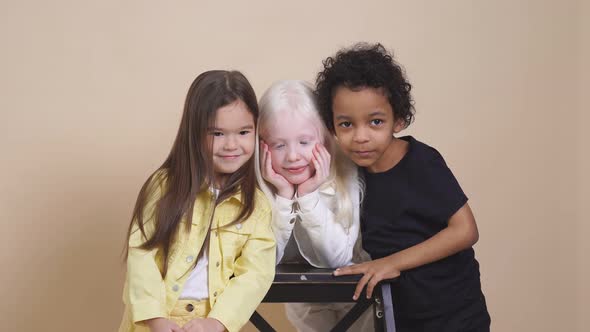 Three Diverse Children with Unusual Appearance Hug Each Other, Posing