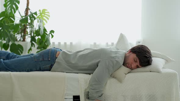 Exhausted Young Man Falling Asleep on Bed Feeling No Energy After Hard Working Day