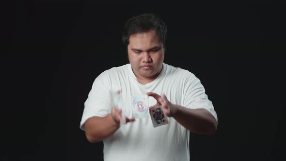 Asian Man Starts Showing His Trick With Cards, Cardistry On Black Background