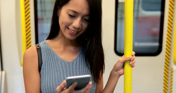 Woman looking at cellphone on train