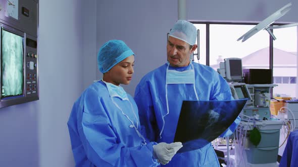 Front view of Multi-ethnic doctors discussing over x-ray report in hospital