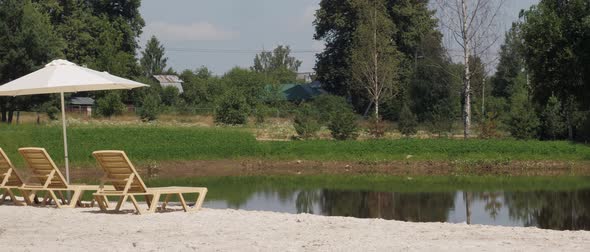 Beach Area with Sand and Loungers Near a Small Lake in a Cottage Village in Nature Rest Near the