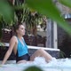 Beautiful Young Woman Relaxes in a Hydromassage Jacuzzi in Swimming Pool - VideoHive Item for Sale