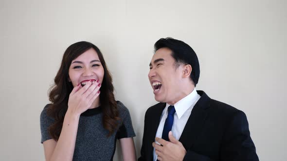 Two happy young business people laughing.