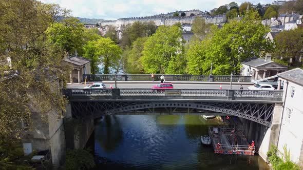 Aerial of a busy road bridge with workers surveying the underside from a temporary pontoon