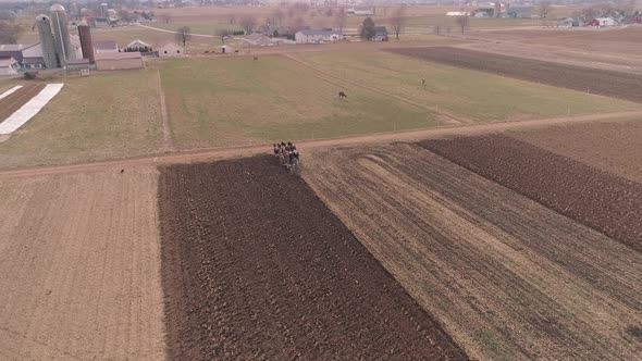 Aerial View of Amish Farm Worker Turning the Field in Early Spring