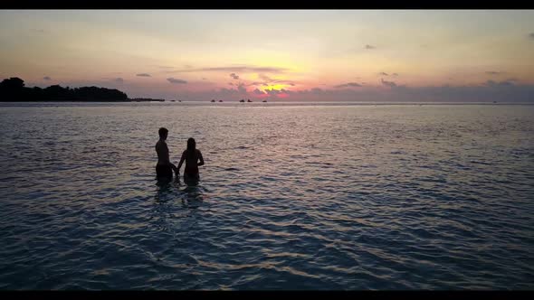 Guy and girl in love on beautiful island beach voyage by shallow sea with white sand background of t