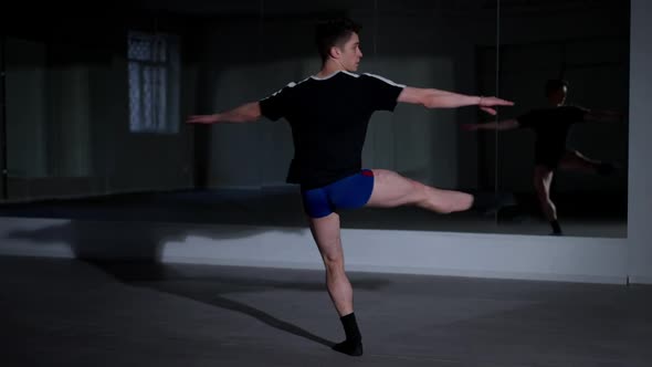 Wide Shot Talented Young Man Spinning Fast in Ballet Position Looking at Camera and Sitting Down