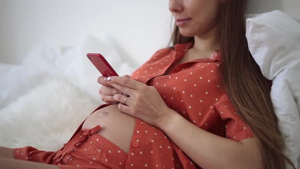 Pregnant Woman Use Phone for Texting and Sit on Bed Spbd