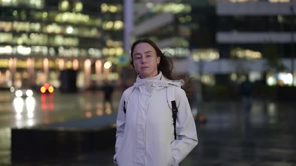 Portrait of a Brunette with Long Hair and in a Light Jacket in the Evening Against the Background of