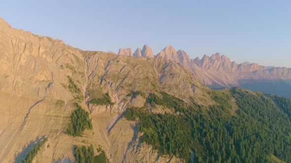 Aerial view above woodland tree coverage on idyllic South Tyrol Peitlerkofel sunlit mountain slope