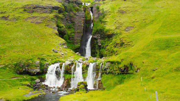 Aerial View Of Large Cascade Waterfall Gluggafoss In Lush Green Iceland Backcountry. 4K Drone.