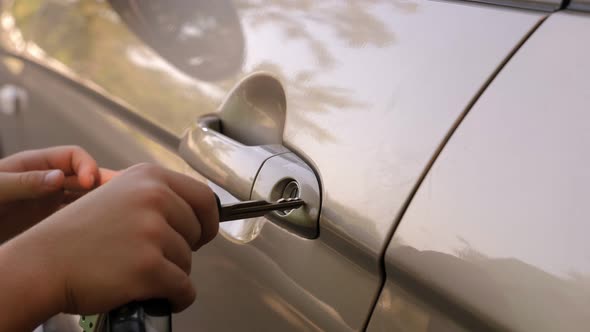 Closeup of a Little Boy Opening a Car with a Key in Summer