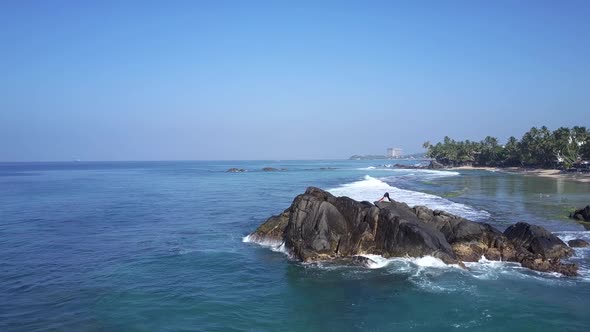 Sporty Girl Stretches on Cliff at Coastline with Palms