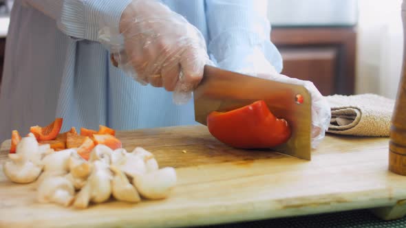 The Chef Cuts Into Squares a Sweet Red Pepper with a Professional Knife