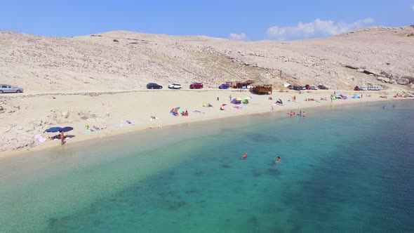 Flying above tourists on isolated beach of Pag island, Croatia