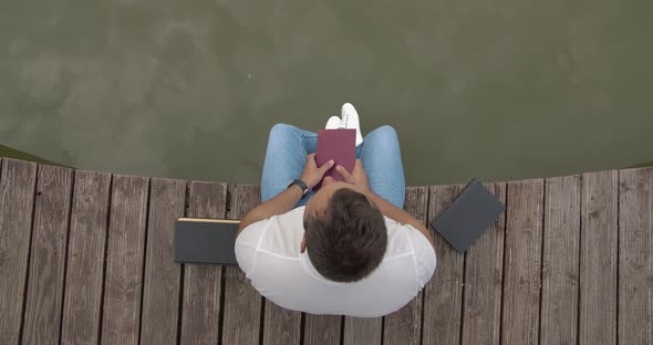 Sitting On A Pier With Books